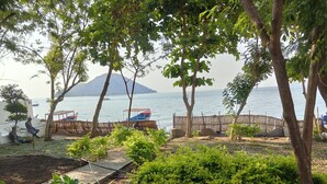 Ein Garten mit Meerblick, einer Holzumzäunung und einem Boot, das an der Wasserkante liegt.