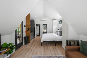 A bedroom with a bed, a window, and a view of the outdoors.
