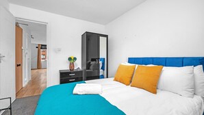 A modern bedroom with a large bed, a wardrobe, and a mirror. - Cozy 1-Bed Flat in Croydon Sleeps 4 - Free Parking (Greater London)