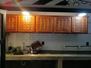 A kitchen with wooden cabinets, a sink, and various kitchen items.