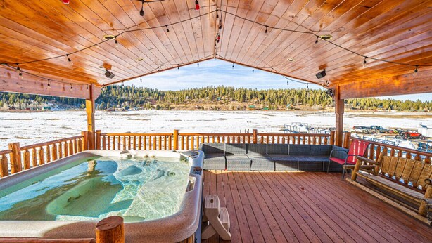 A wooden deck with a hot tub, outdoor seating, and a view of a snowy landscape. - Hot Tub with Meadow Views! Pet Friendly! (Duck Creek Village)
