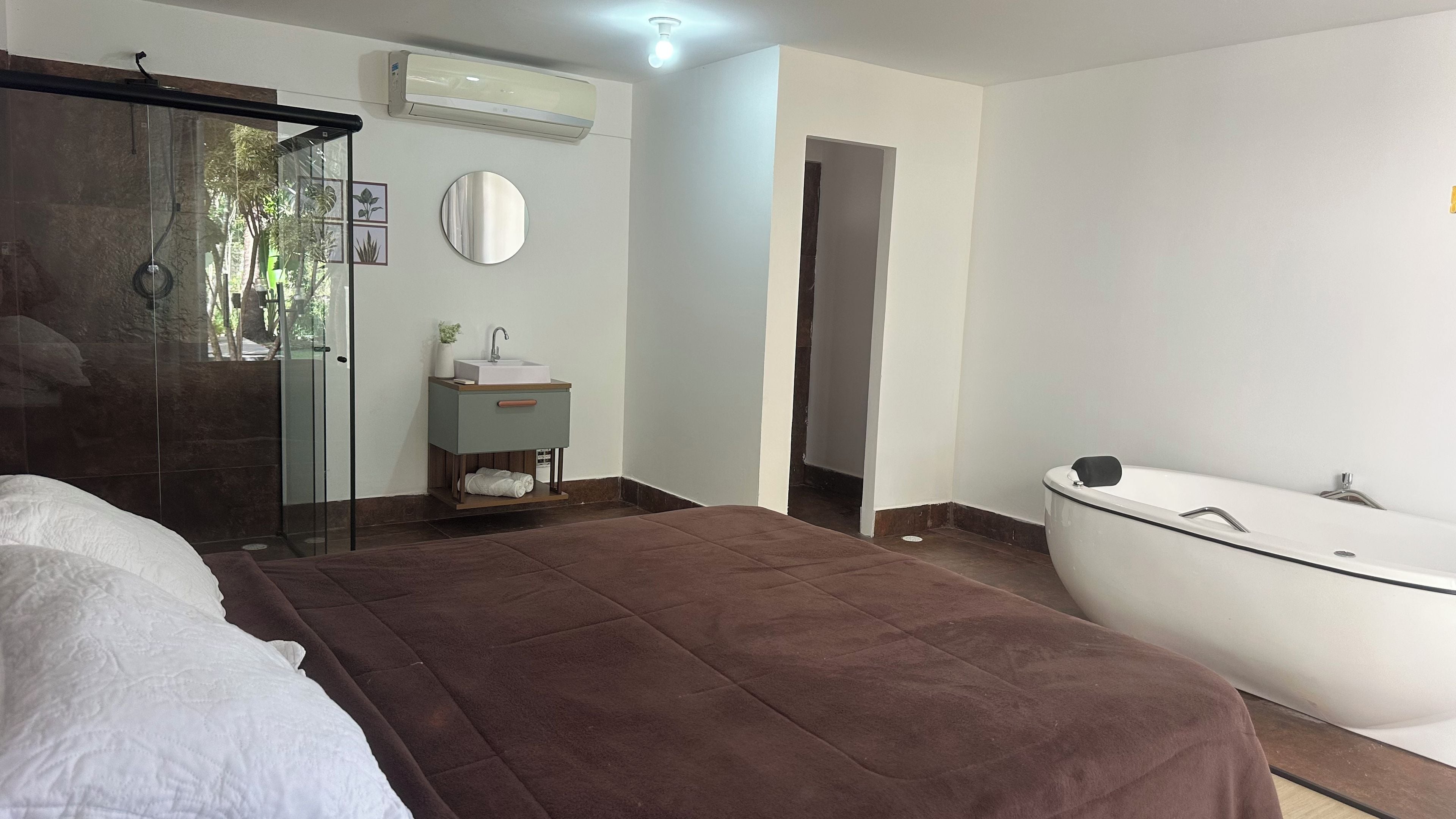 Een moderne slaapkamer met een groot bed, een inloopdouche en een badkamer met bad.