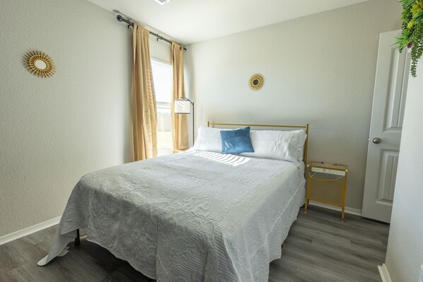 A neatly arranged bedroom with a bed, a bedside table, a nightstand, and a wall-mounted decorative item. - Fabulous 3-bedroom house with AC in charming Conway (Conway)