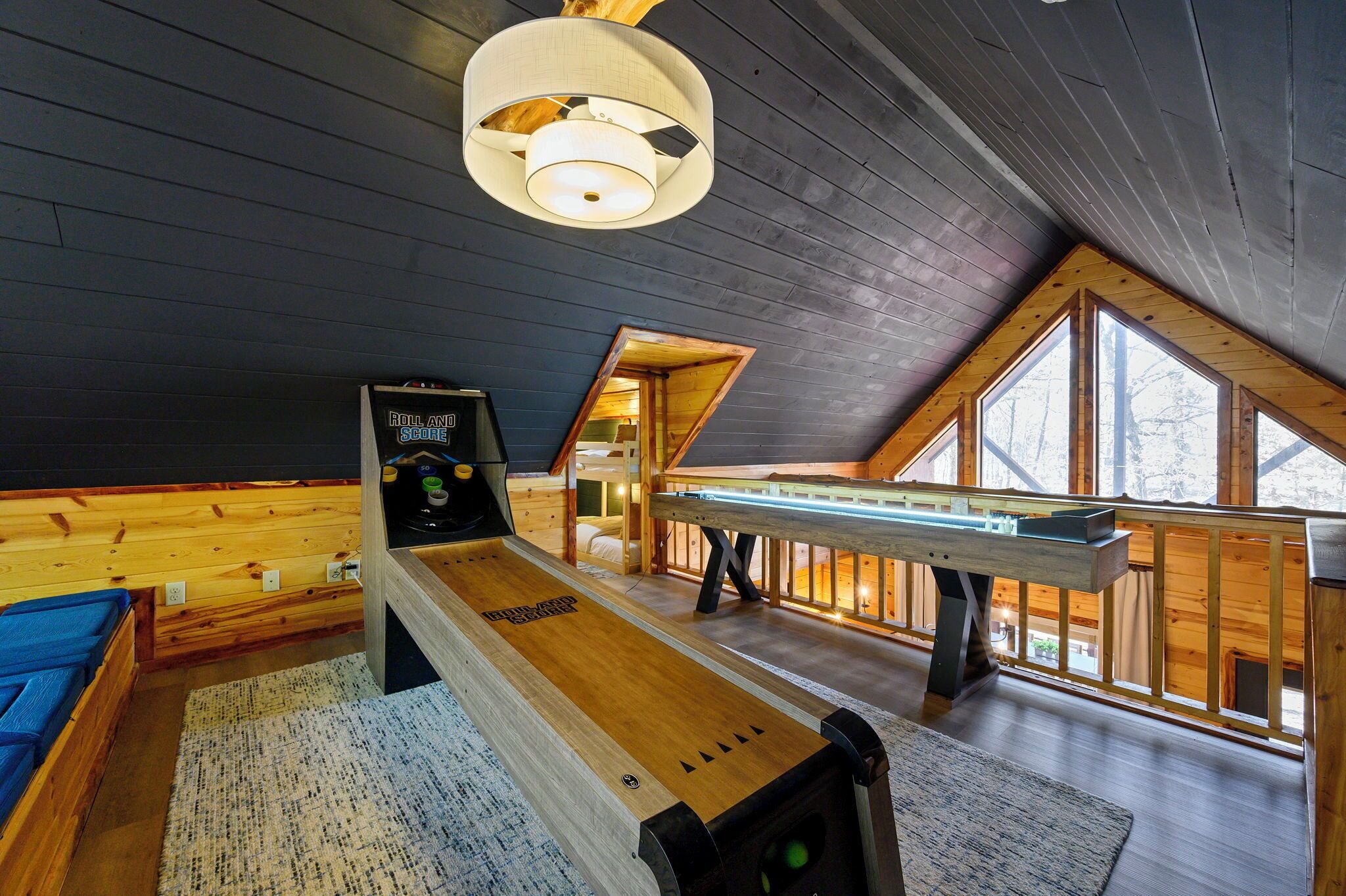 Tunnelmallinen huone, jossa on shuffleboard-pöytä, biljardipöytä ja suuri ikkuna, josta tulee runsaasti luonnonvaloa.