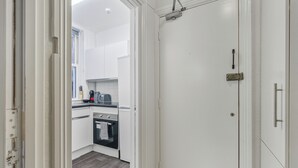 Eine moderne Küche mit weißen Schränken, einer schwarzen Arbeitsplatte und einem eingebauten Backofen.