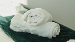 A neatly folded white towel on a dark green towel on a bed. - NewStreet 1Bed Birmingham with Self Checkin (Birmingham)