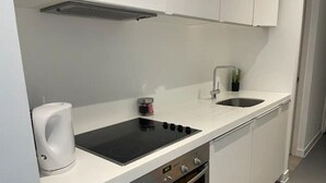 A modern kitchen with a built-in stove, oven, and sink. - NewStreet 1Bed Birmingham with Self Checkin (Birmingham)