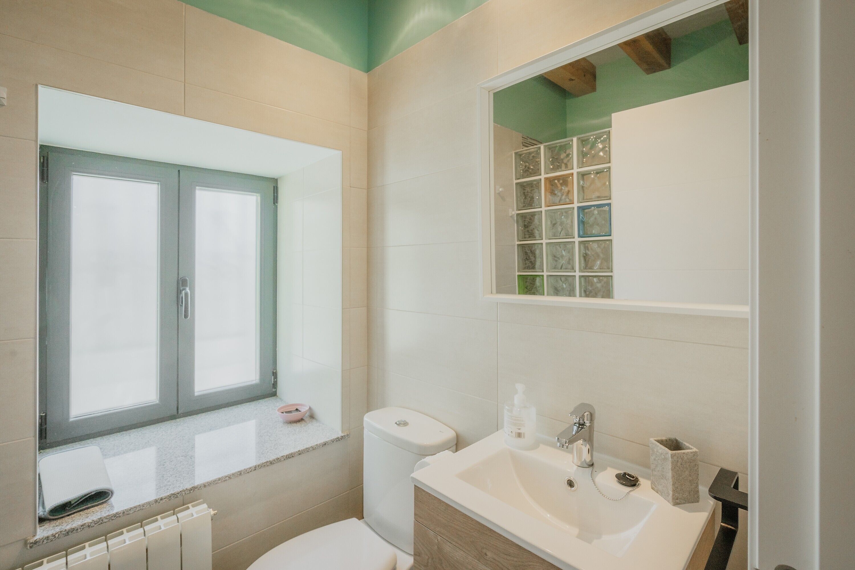 Ein Badezimmer mit Toilette, Waschbecken und Fenster.