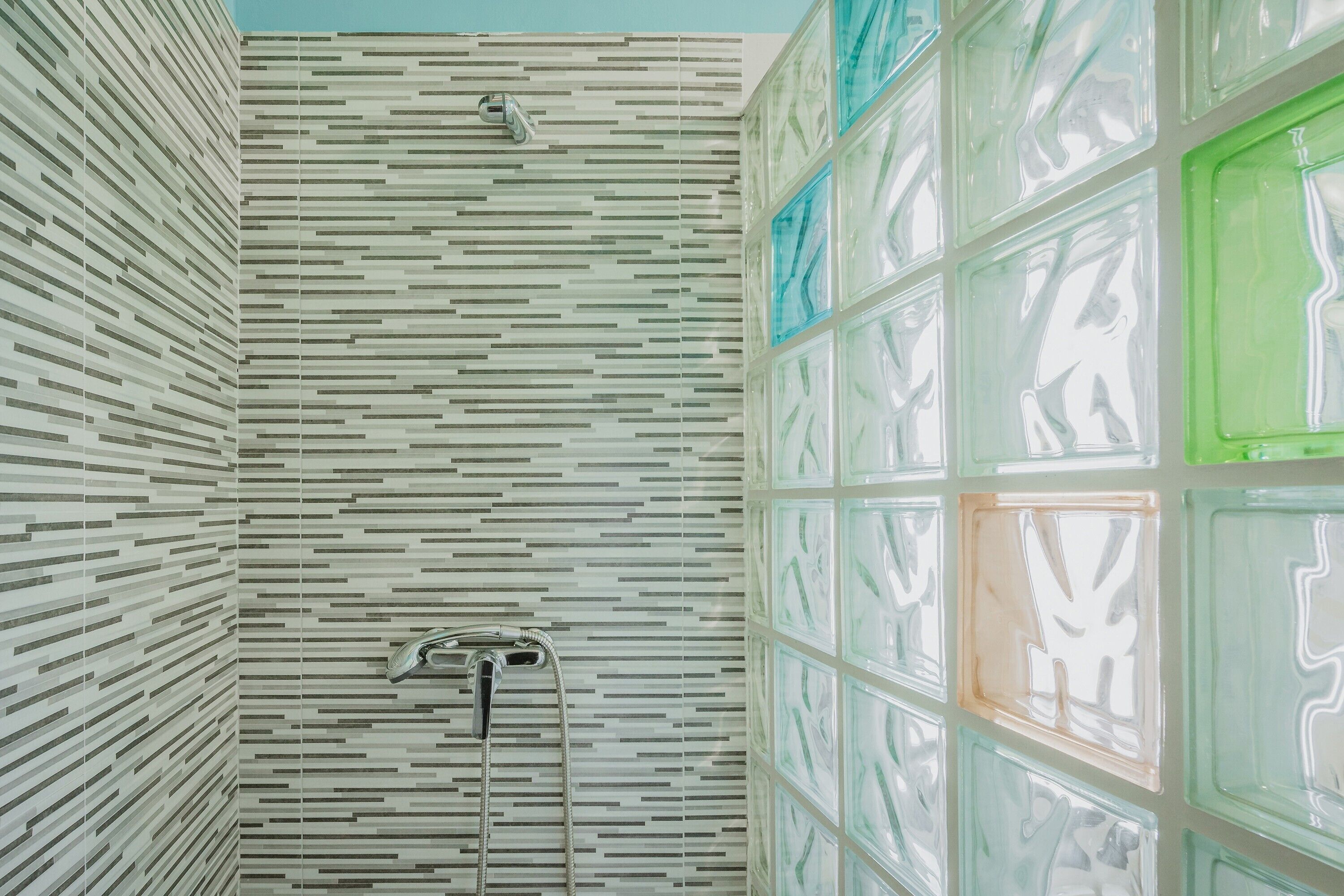 Un bagno dal design moderno con una parete decorata e uno sportello doccia in vetro.