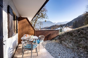 A balcony with a table and chairs, overlooking a mountainous landscape. - 2-room first floor apartment with terrace 4 (Oberaudorf)