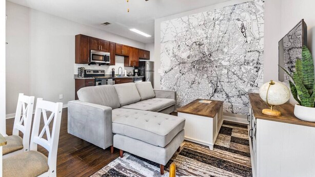 A modern living room with a sectional sofa, a coffee table, and a map mural on the wall. - `Amazing value, convenient location!` +Free prkng! (Nashville)