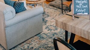 A cozy living room with a fireplace, comfortable seating, and a welcome sign. - The Marigold at Mill Creek (Topping)