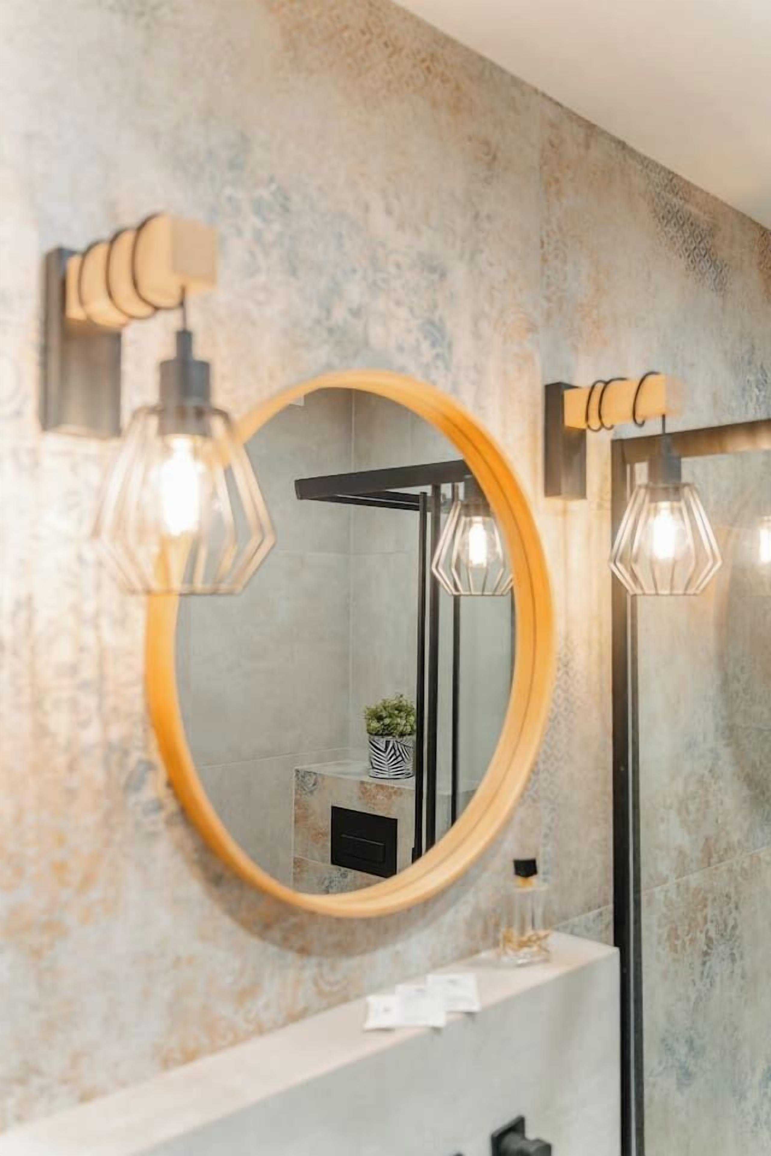 Une salle de bain avec un miroir rond, un porte-serviettes et une étagère contenant des articles de toilette.