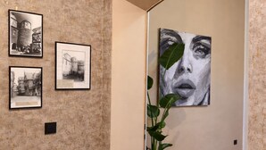 Taidegalleria, jossa on kehystettyjä valokuvia ja suuri maalaus seinällä.
