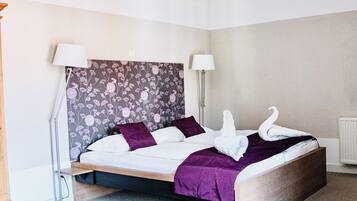 Ein modernes Schlafzimmer mit einem Bett, zwei Lampen, einer Heizung und einer Stehlampe.