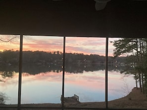 A view of a lake at sunset with a bench in the foreground and trees on the right. - Lakeside Leisure - A Hidden Gem in Metro Atlanta (Conyers)
