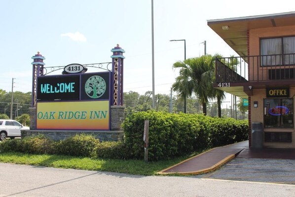 A sign for Oak Ridge Inn with a welcome message, a tree logo, and the number 4131.