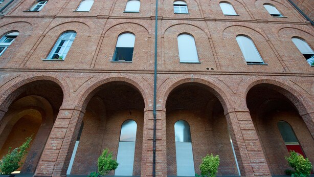A red brick building with arched windows and a central column. - Loft Trevisan • Elegant loft with private garage (Bra)