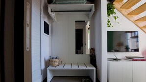 A hallway with a bench, a basket, and a pair of slippers. - Loft Trevisan • Elegant loft with private garage (Bra)