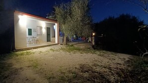A small, well-lit building with a patio area, a door, and a window with shutters. - Detached apartment in residence with swimming pool (Peschici)