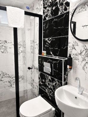 A bathroom with a toilet, sink, and shower. - Kaya Hotel (Antalya)