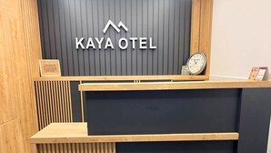 A reception area with a wooden desk, a clock, and a framed certificate on the wall.
