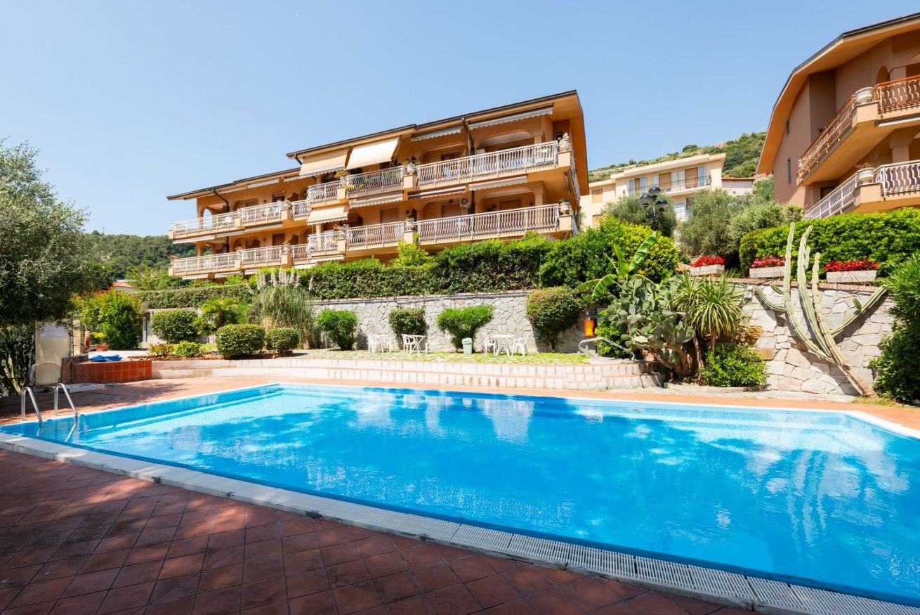 Une piscine à l’eau d’un bleu limpide, entourée d’une terrasse en briques.
