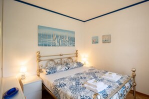 A bedroom with a bed, bedside tables, and wall art. - The apartment is located in an area of ​​Bordighera surrounded by greenery, the perfect solution for a relaxing holiday, with all the main comforts!The private parking in the garage, the shared outdoor swimming pool, the large covered terrace with ou (Bordighera)