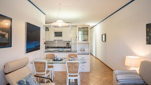 Un espacio habitable compacto con comedor, kitchenette y zona de estar.