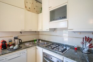 A kitchen with white cabinets, a gas stove, a sink, and a dishwasher. - The apartment is located in an area of ​​Bordighera surrounded by greenery, the perfect solution for a relaxing holiday, with all the main comforts!The private parking in the garage, the shared outdoor swimming pool, the large covered terrace with ou (Bordighera)