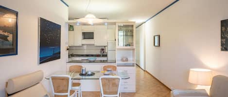 A compact living space with a dining area, kitchenette, and seating area.