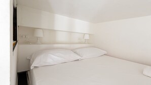 A single bed with white bedding, two bedside lamps, and a white wall. - GuestHost - Cozy and quiet apartment in Milan! (Milano)