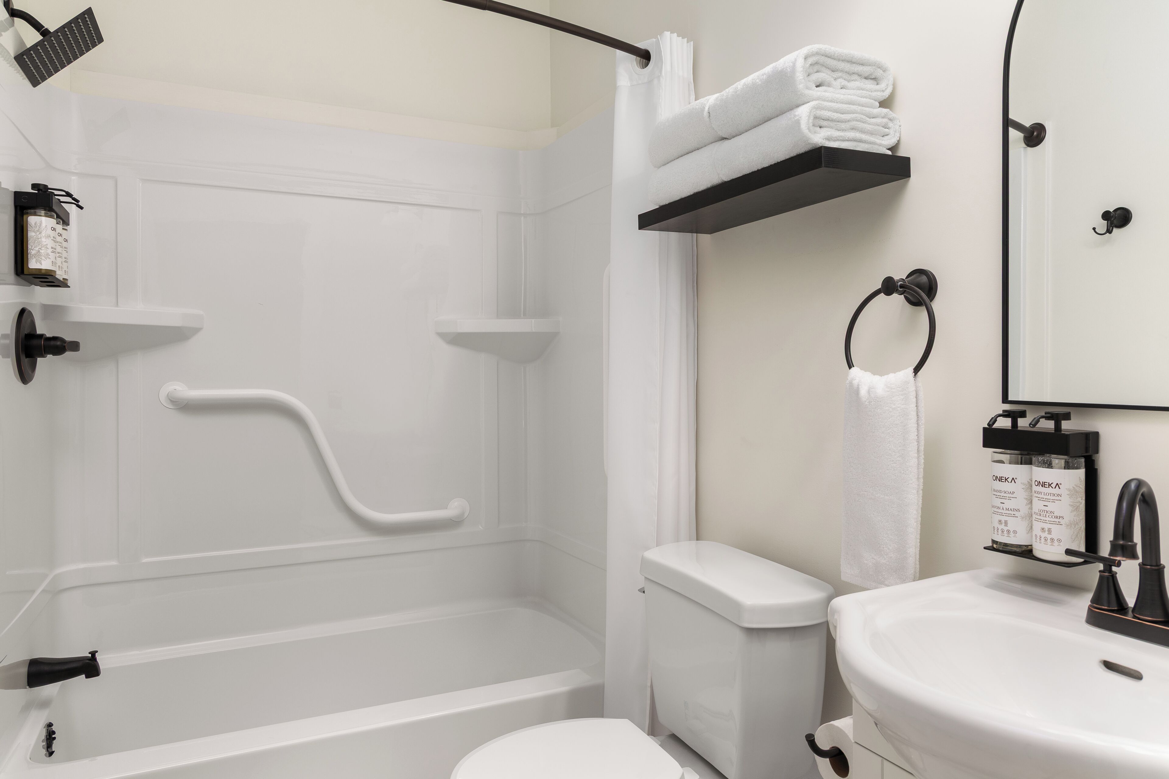 A modern bathroom with a shower, toilet, and sink.