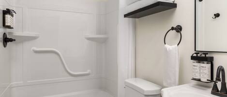 A modern bathroom with a shower, toilet, and sink.