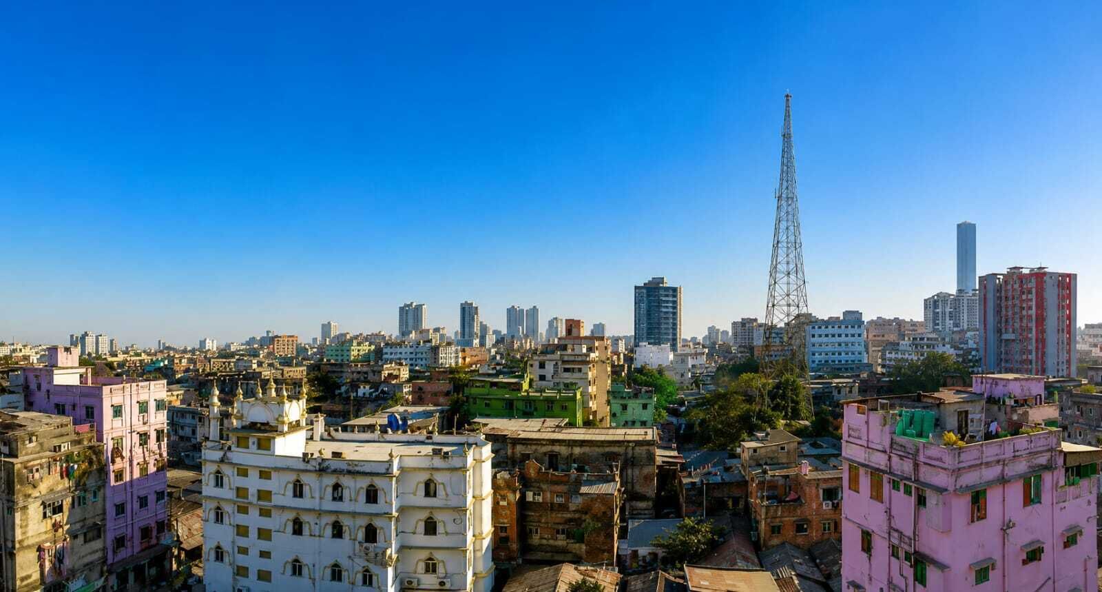 A cityscape with a mix of residential and commercial buildings, including a prominent tower structure.