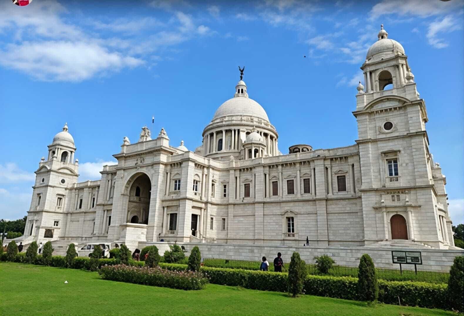 A large, historic building with multiple domes and towers, surrounded by well-maintained gardens.