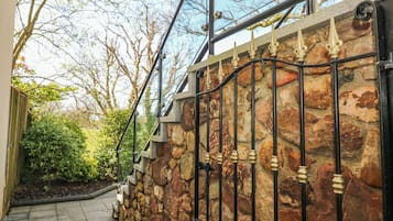 Un muro de piedra con barandillas de metal y una escalera de piedra.
