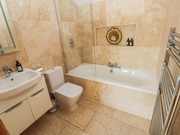 A bathroom with a sink, toilet, bathtub, and a shower. - Gower Retreats - Rose Apartment (Swansea)