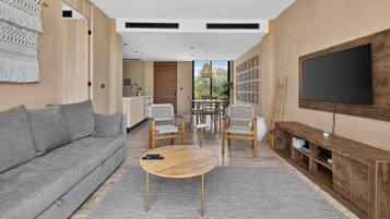 A modern living room with a grey sofa, wooden coffee table, and a TV on a wooden stand.