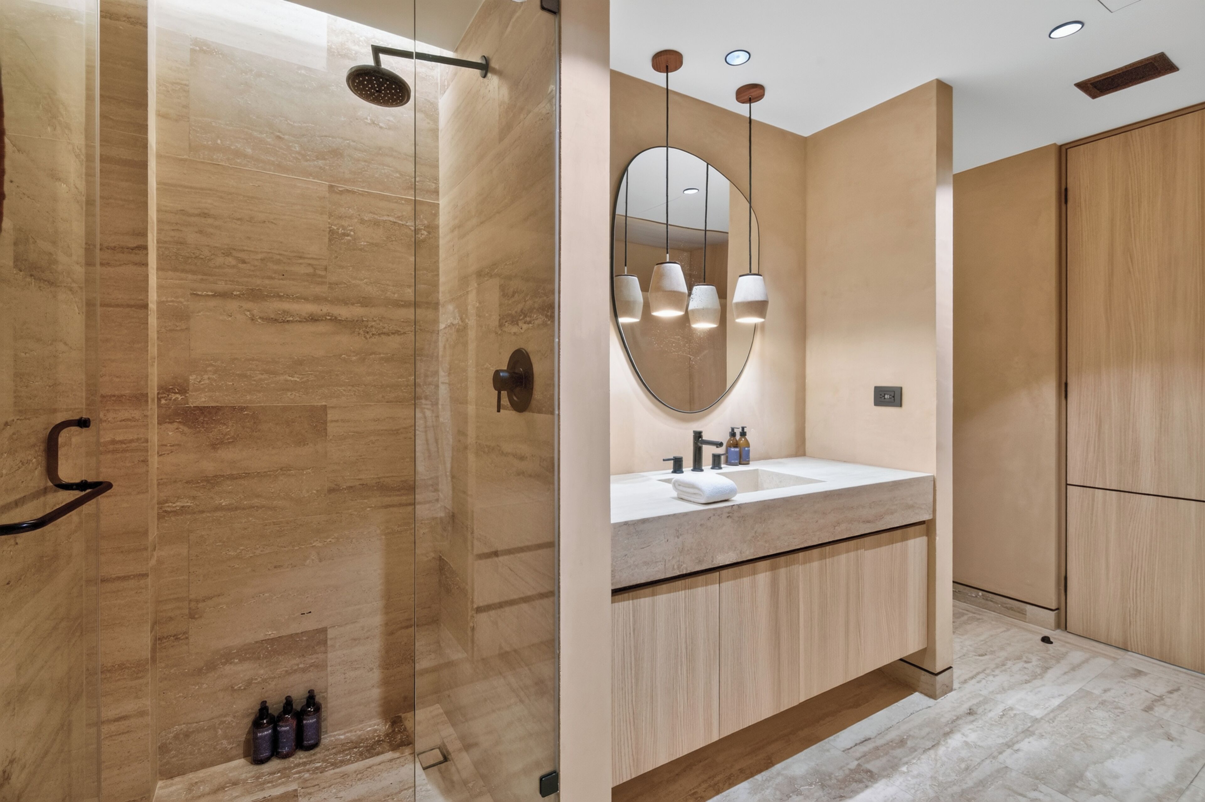 A modern bathroom with a walk-in shower, a large mirror, and a vanity with a sink.