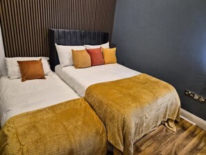 A double bed with a dark headboard and two bedside tables. - Modern, luxury studio 5 minutes walk to the tube station (London)