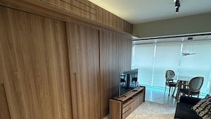 Une chambre moderne dotée d’une grande armoire, d’un téléviseur à écran plat et d’un canapé.