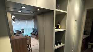 Un intérieur moderne avec un bureau intégré, des étagères et un coin salon.