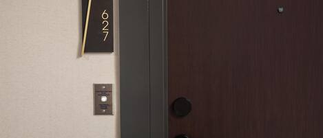 A door with a number plate, a door handle, and a small plaque with text.