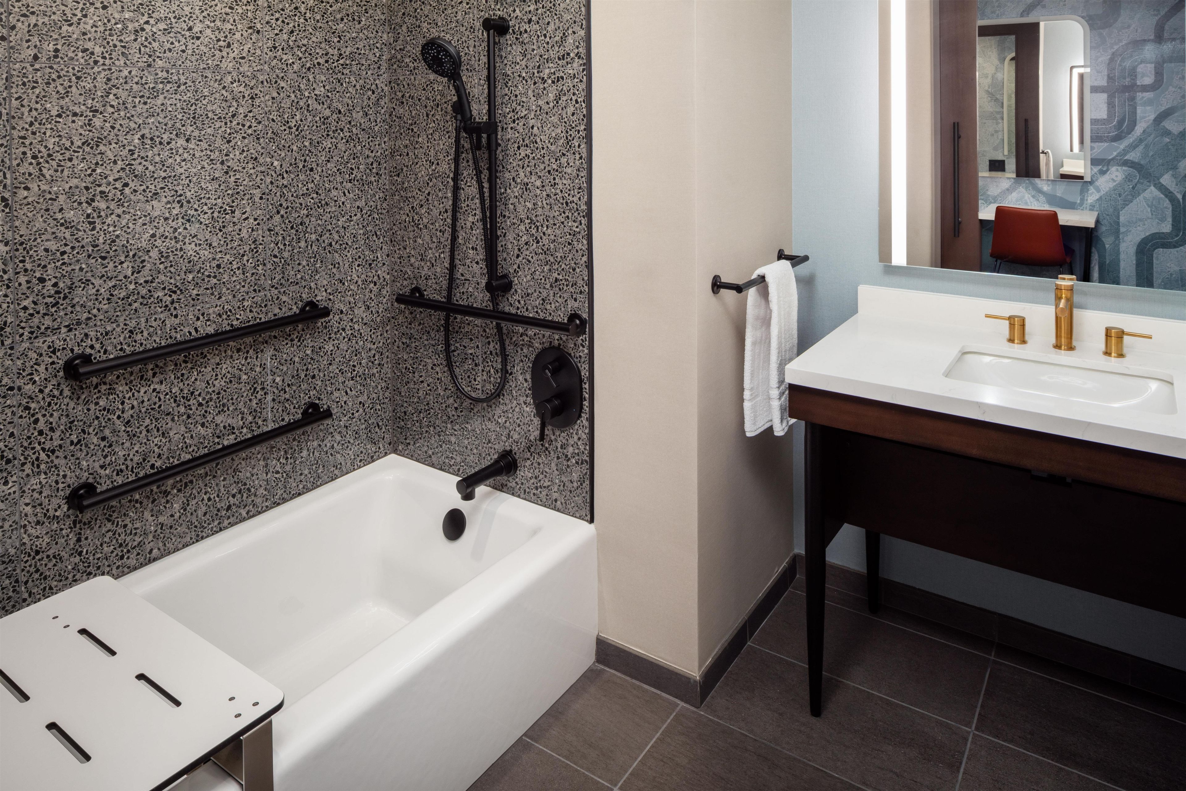 A modern bathroom with a freestanding bathtub, a vanity with a mirror, and a shower area.