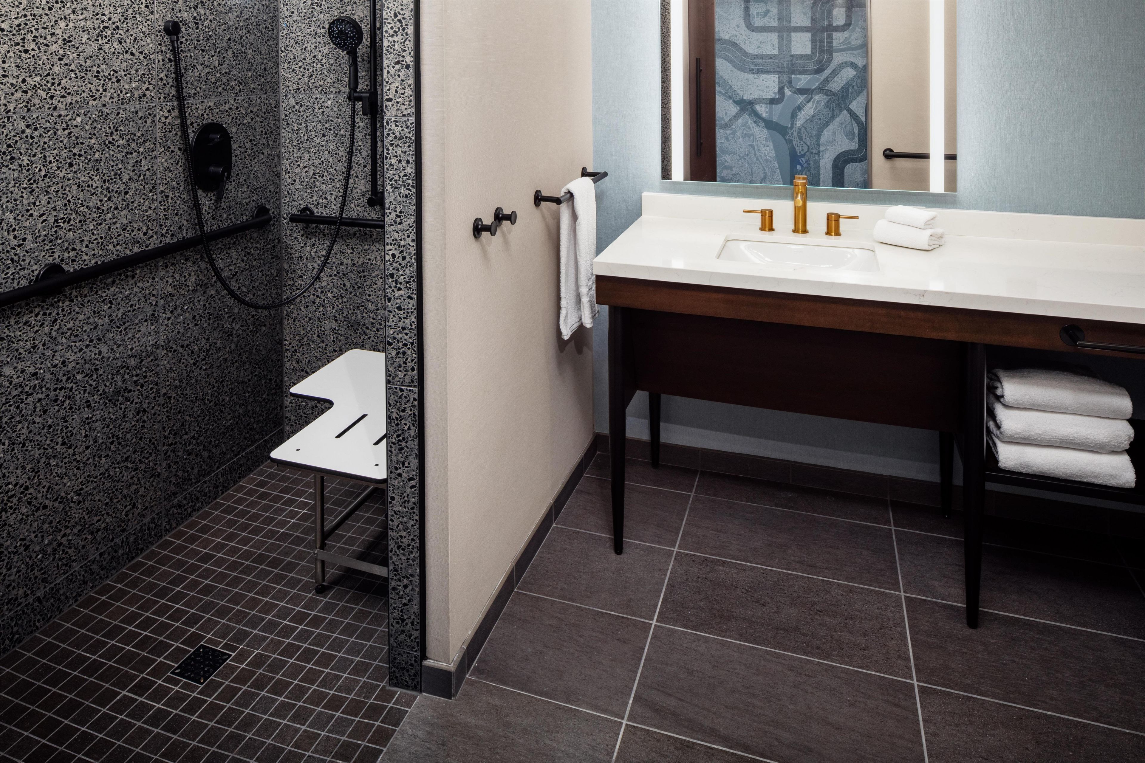 Un baño con ducha, lavabo y espejo.