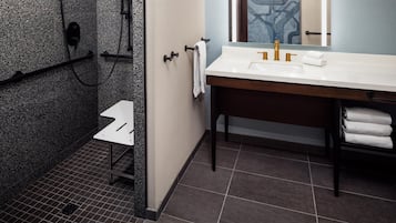 Un baño con ducha, lavabo y espejo.