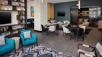 A modern living room with a flat-screen TV, seating area, and a dining space.