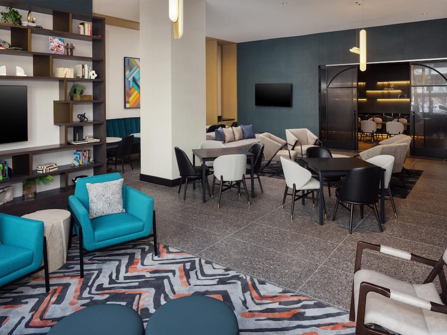 A modern living room with a flat-screen TV, seating area, and a dining space.