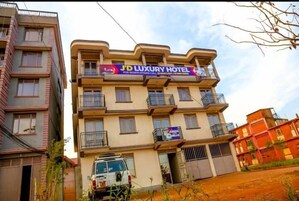 Un edificio de varios pisos con un letrero que dice 'J'D Luxury Hotel'.